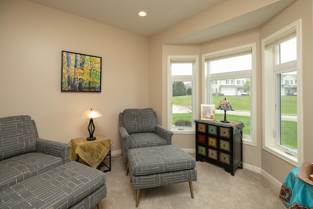 living area with baseboards, recessed lighting, a healthy amount of sunlight, and light colored carpet
