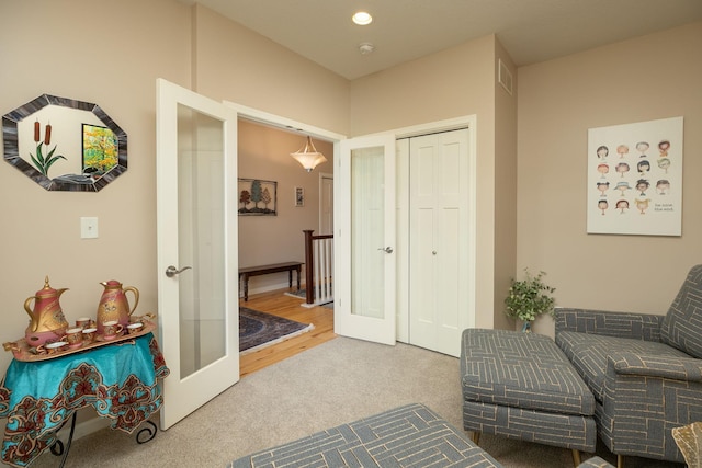 living area with carpet floors, recessed lighting, visible vents, and french doors