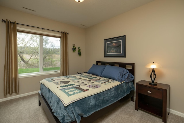 bedroom featuring baseboards, carpet flooring, and multiple windows