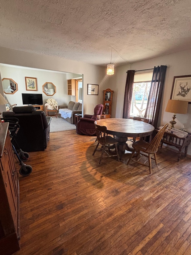 dining area featuring a textured ceiling and hardwood / wood-style floors