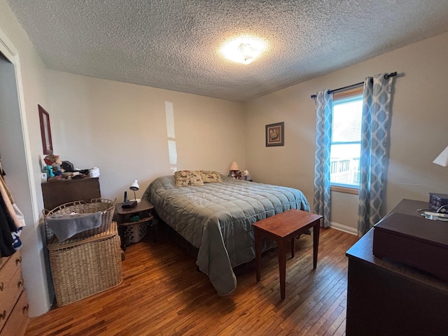 bedroom featuring hardwood / wood-style flooring and a textured ceiling