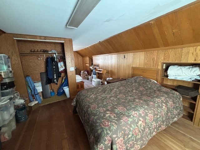 bedroom featuring wood walls, wood finished floors, and vaulted ceiling