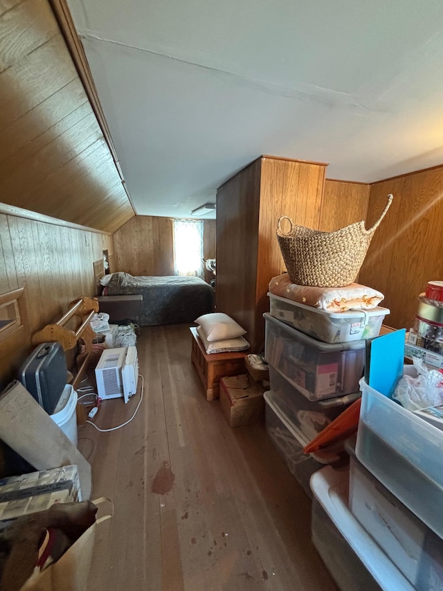 interior space featuring vaulted ceiling, wood walls, and hardwood / wood-style floors