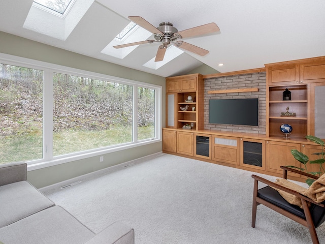 living area with carpet, baseboards, lofted ceiling with skylight, and a wealth of natural light