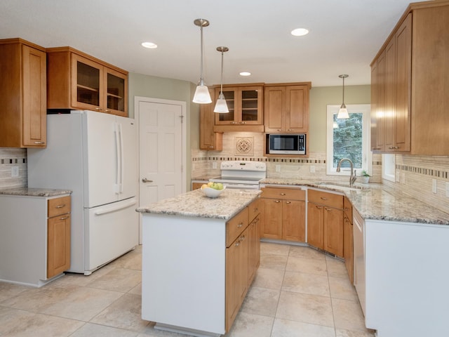 kitchen featuring glass insert cabinets, a sink, white appliances, decorative backsplash, and a kitchen island