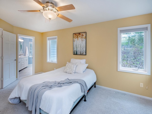 bedroom featuring light colored carpet, baseboards, and multiple windows