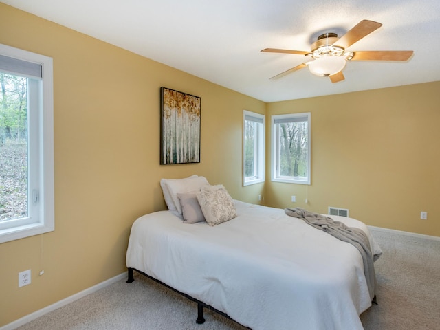 bedroom featuring carpet, visible vents, baseboards, and ceiling fan