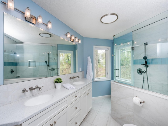 bathroom featuring a sink, tasteful backsplash, and tiled shower