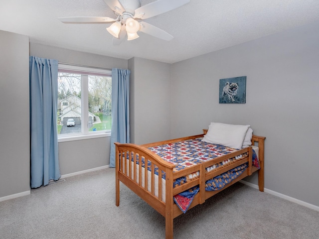 carpeted bedroom featuring baseboards and a ceiling fan