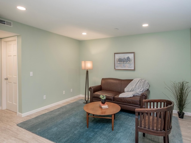living area with recessed lighting, visible vents, and wood finished floors