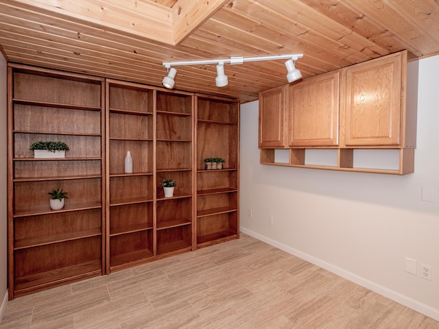 basement with rail lighting, baseboards, light wood-type flooring, and wooden ceiling