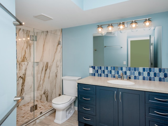 full bathroom with vanity, toilet, tasteful backsplash, and a marble finish shower