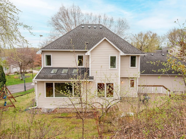 rear view of house featuring roof with shingles
