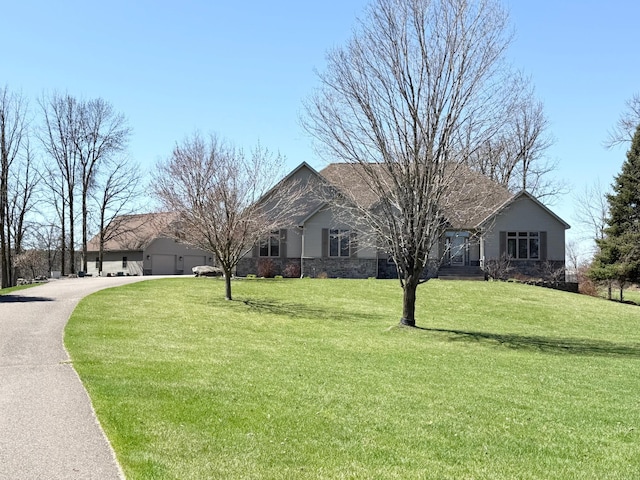 view of front of house featuring driveway and a front yard