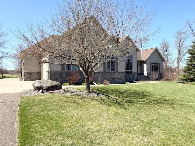 single story home with a garage, concrete driveway, a front lawn, and stone siding