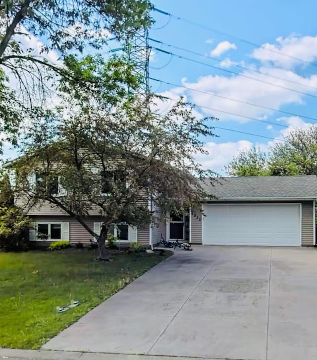 view of front of home with an attached garage, driveway, and a front yard