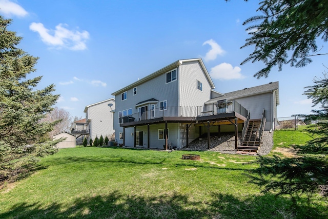 rear view of house featuring stairway, a deck, a yard, and an outdoor fire pit
