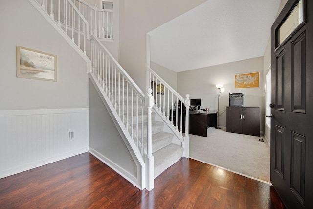 stairway featuring baseboards, wainscoting, and wood finished floors