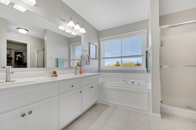 full bath featuring a sink, double vanity, tile patterned floors, a shower stall, and a bath