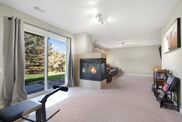 living room with carpet floors, baseboards, visible vents, and a fireplace