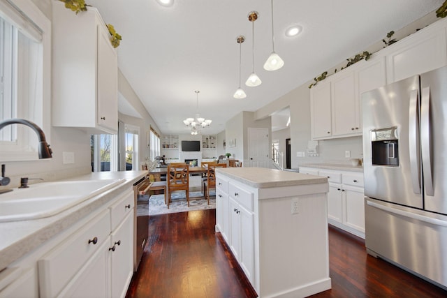 kitchen with dark wood-style flooring, appliances with stainless steel finishes, a sink, and an inviting chandelier