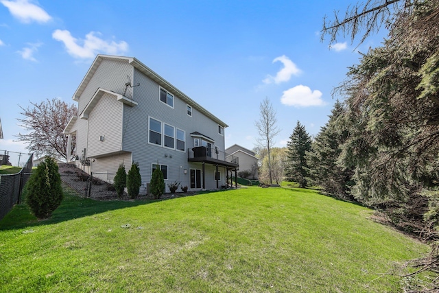 back of property with a lawn, a deck, and fence
