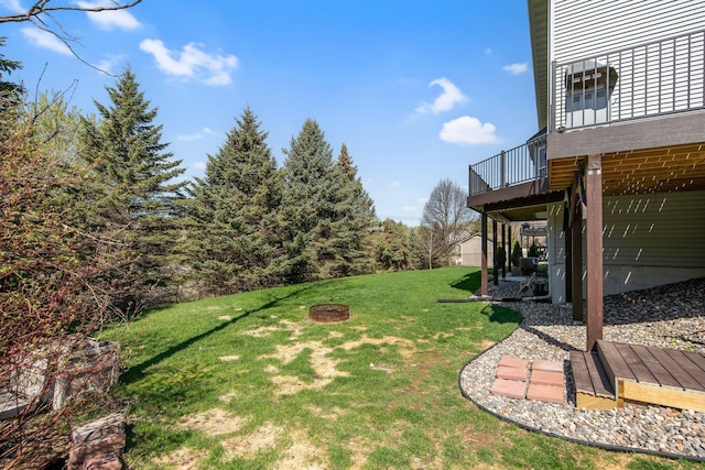 view of yard featuring a deck and a fire pit