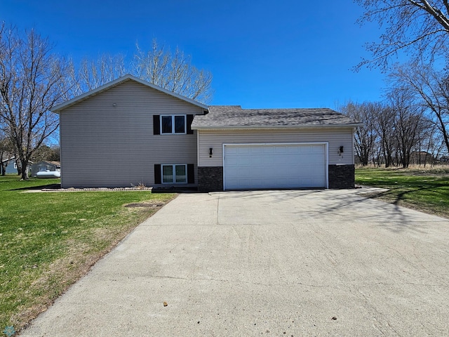 split level home featuring an attached garage, driveway, and a front yard