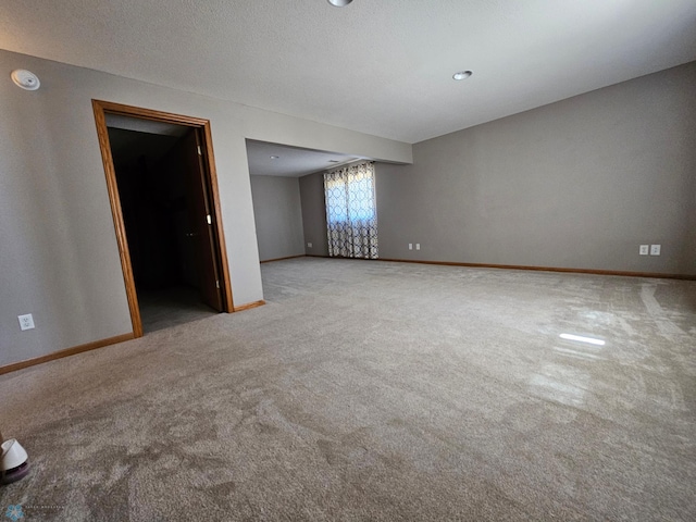 carpeted spare room featuring baseboards