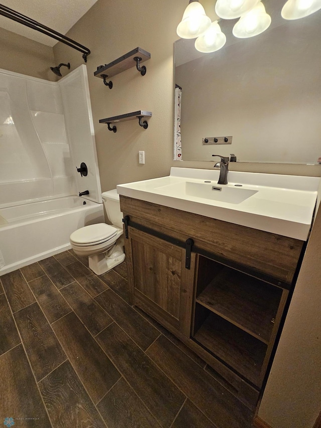 bathroom featuring vanity, toilet, wood finished floors, and shower / washtub combination
