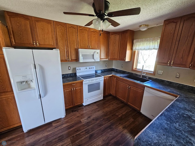 kitchen featuring a ceiling fan, white appliances, a textured ceiling, brown cabinets, and a sink