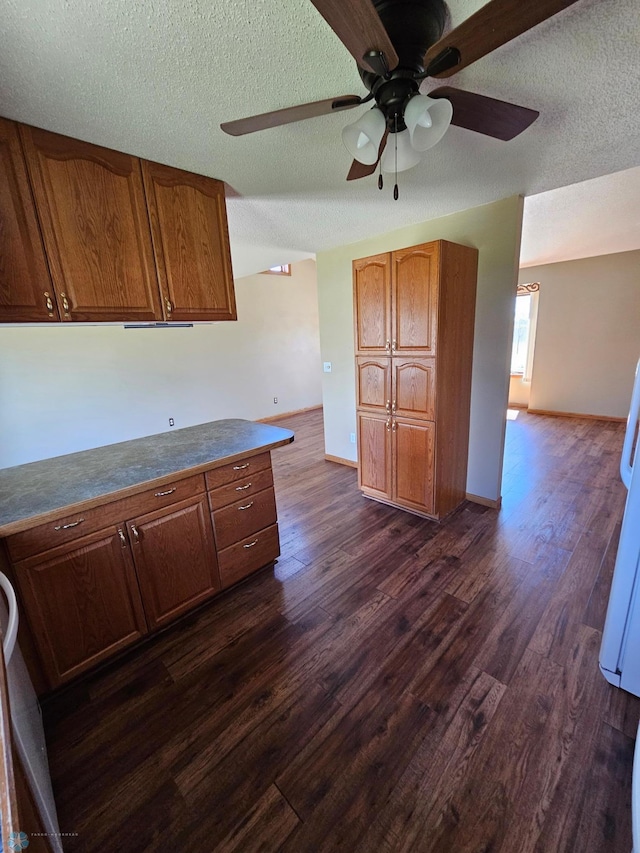 kitchen with brown cabinets, dark wood-style flooring, and ceiling fan