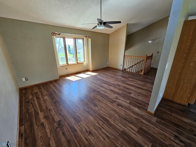 spare room featuring baseboards, a ceiling fan, a textured ceiling, and dark wood-type flooring