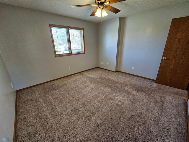 empty room featuring light colored carpet, a textured ceiling, ceiling fan, and baseboards