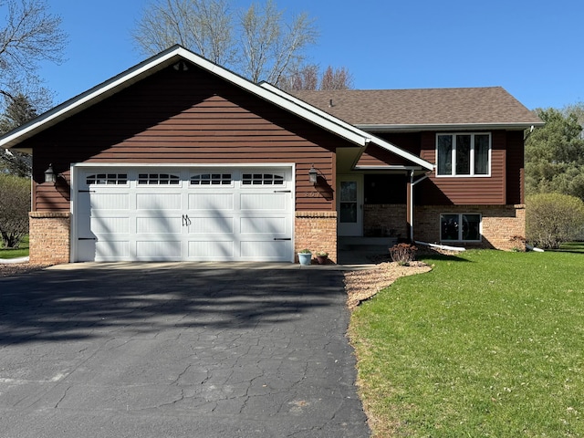 view of front of property featuring an attached garage, aphalt driveway, a front lawn, and brick siding
