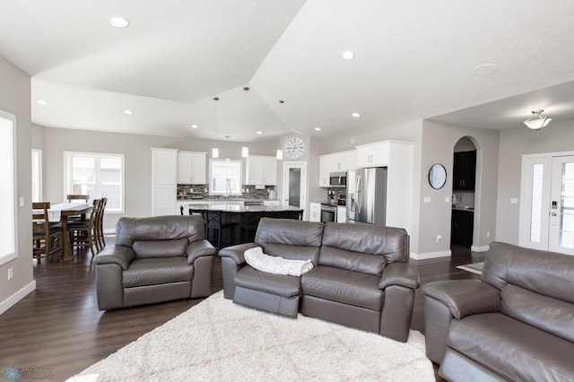 living room with dark wood-style flooring, lofted ceiling, baseboards, and recessed lighting