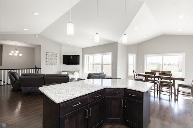 kitchen with a center island, dark wood-style flooring, an inviting chandelier, open floor plan, and vaulted ceiling