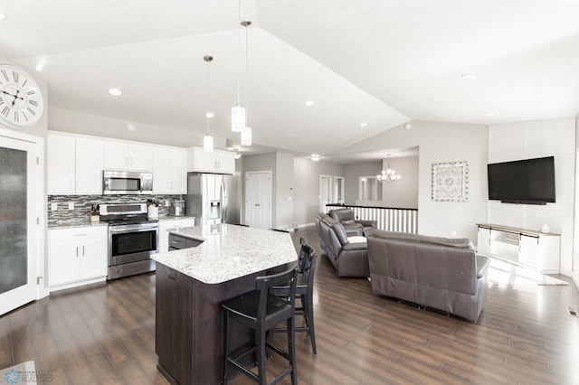 kitchen with lofted ceiling, stainless steel appliances, dark wood finished floors, open floor plan, and a kitchen island