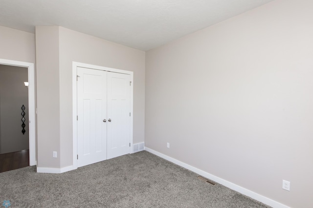 unfurnished bedroom featuring carpet floors, baseboards, and a closet