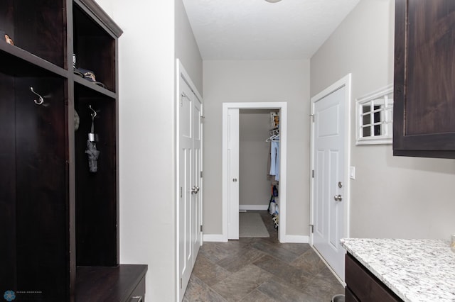mudroom with baseboards and stone finish flooring
