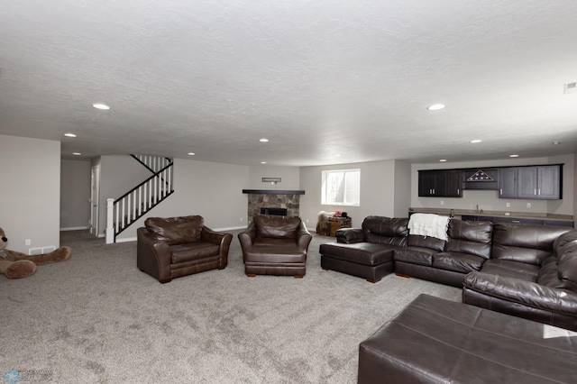 living room with stairs, recessed lighting, carpet flooring, baseboards, and a stone fireplace