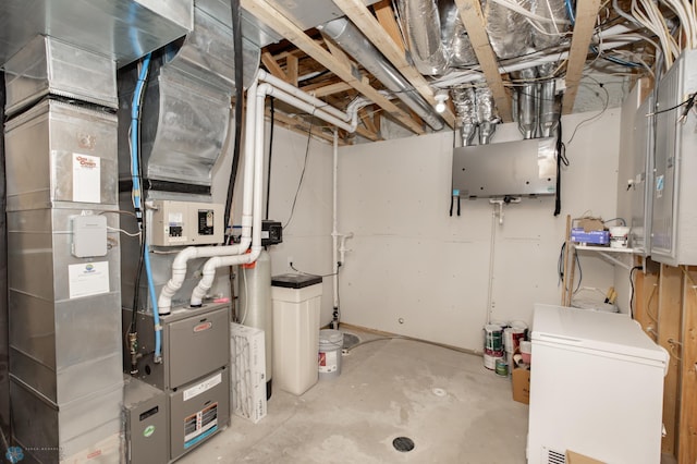 unfinished basement featuring refrigerator, heating unit, and a water softener system