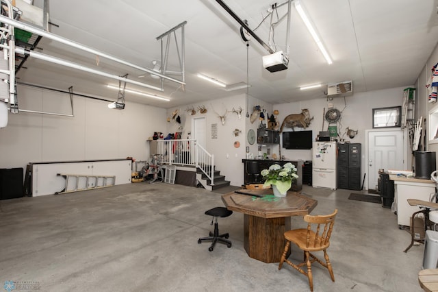 garage with freestanding refrigerator and a garage door opener