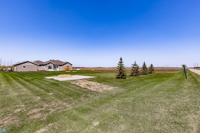 view of grassy yard with a rural view