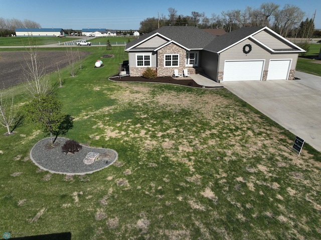 ranch-style house with stone siding, an attached garage, driveway, and a front yard