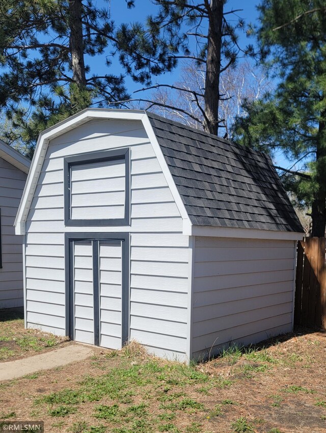 garage with a storage shed and fence