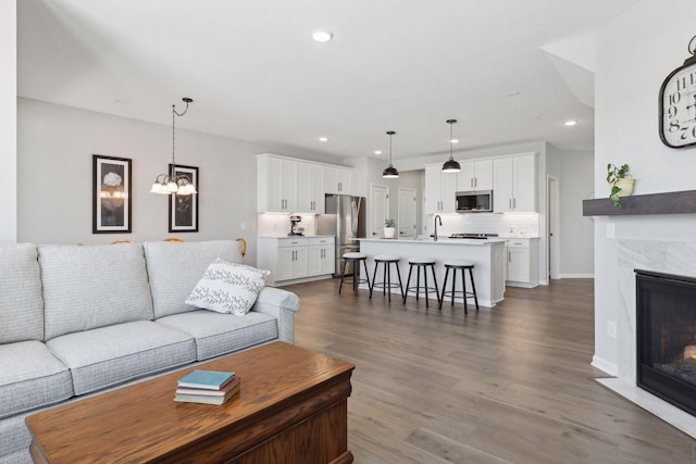 173 Junco Rd N, Lake Elmo, MN 55042 - living area with dark wood finished floors, recessed lighting, a chandelier, a premium fireplace, and baseboards
