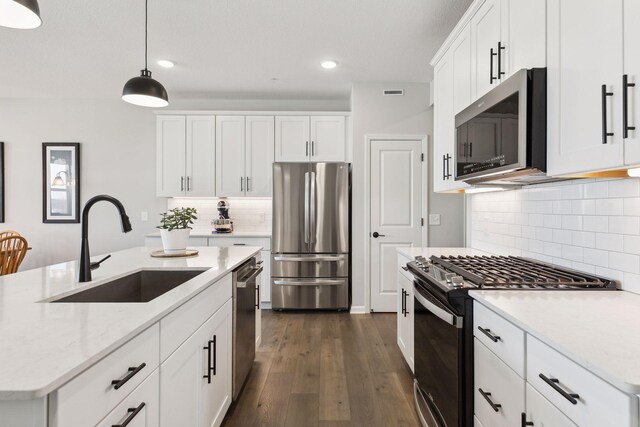 173 Junco Rd N, Lake Elmo, MN 55042 - kitchen with appliances with stainless steel finishes, a sink, decorative backsplash, dark wood-style flooring, and hanging light fixtures