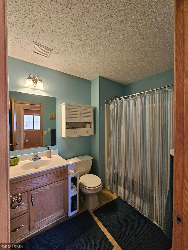 bathroom featuring visible vents, vanity, toilet, a textured ceiling, and a shower with curtain