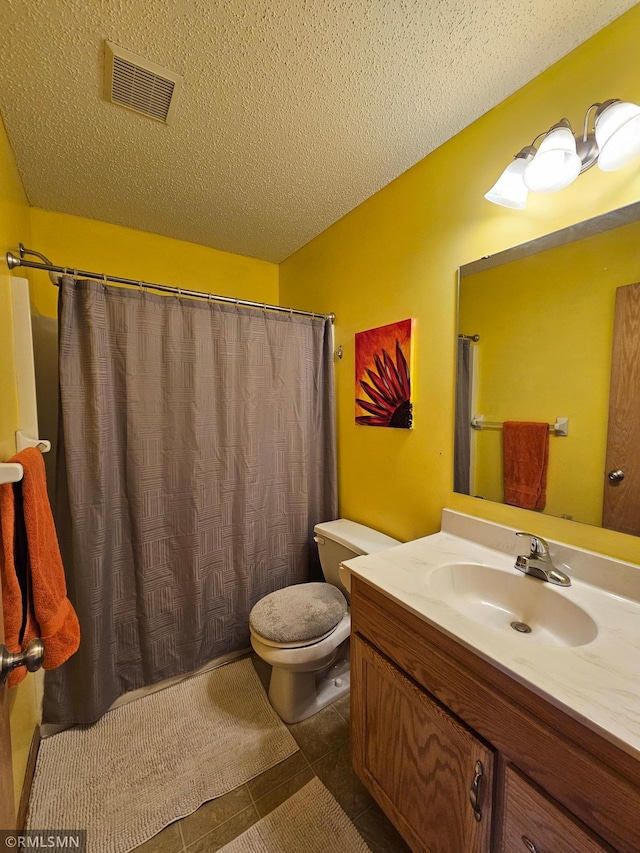 bathroom with visible vents, tile patterned flooring, vanity, toilet, and a textured ceiling